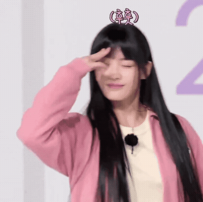 A Woman With Long Black Hair Wearing A Pink Jacket And A Pink Crown On Her Head GIF