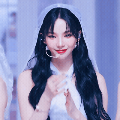 A Woman With Long Black Hair Wearing A White Dress And Veil GIF