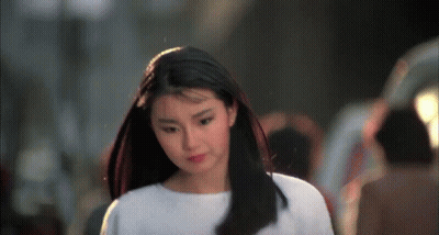 A Woman With Long Black Hair Wearing A White Shirt GIF