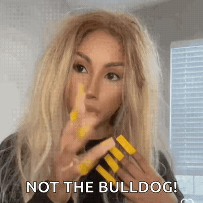 A Woman With Long Blonde Hair And Yellow Nails Is Making A Funny Face And Says `` Not The Bulldog '' . GIF