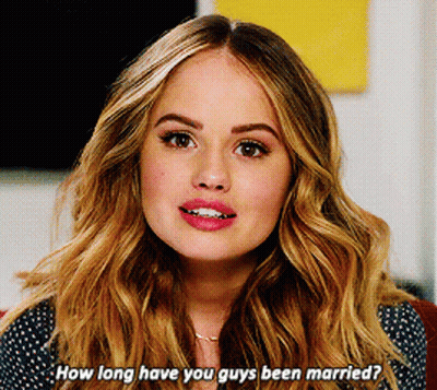 A Woman With Long Blonde Hair Is Asking How Long Have You Guys Been Married GIF