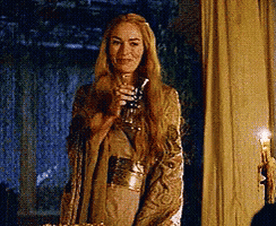 A Woman With Long Blonde Hair Is Holding A Glass In Her Hand . GIF