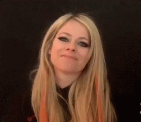 A Woman With Long Blonde Hair Is Making A Face . GIF