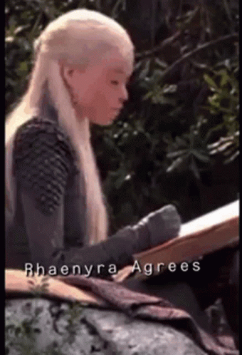 A Woman With Long Blonde Hair Is Reading A Book . GIF