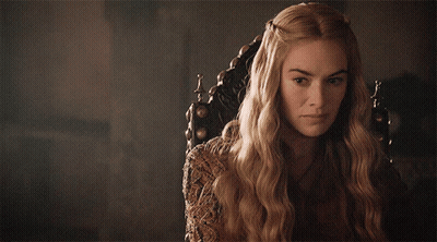 A Woman With Long Blonde Hair Is Sitting In A Chair And Looking At The Camera GIF