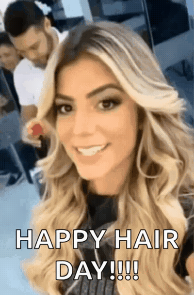 A Woman With Long Blonde Hair Is Smiling And Looking At The Camera With The Words `` Happy Hair Day ! '' GIF