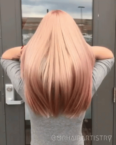 A Woman With Long Blonde Hair Is Standing In Front Of A Door With The Words @Mrhairartistry On The Bottom GIF