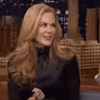 A Woman With Long Blonde Hair Is Wearing A Black And White Striped Shirt GIF