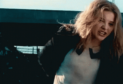 A Woman With Long Blonde Hair Is Wearing A Black Jacket GIF