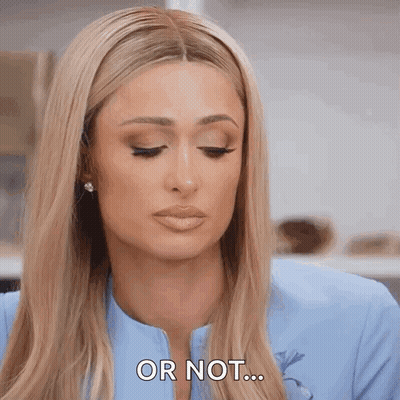 A Woman With Long Blonde Hair Is Wearing A Blue Jacket And Earrings And Says Or Not . GIF