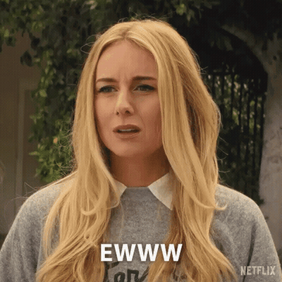 A Woman With Long Blonde Hair Is Wearing A Gray Sweater And Says Ewww GIF