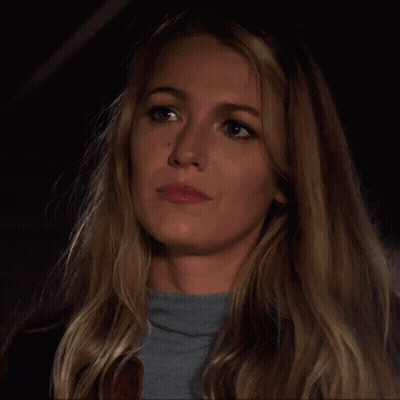 A Woman With Long Blonde Hair Is Wearing A Grey Sweater GIF