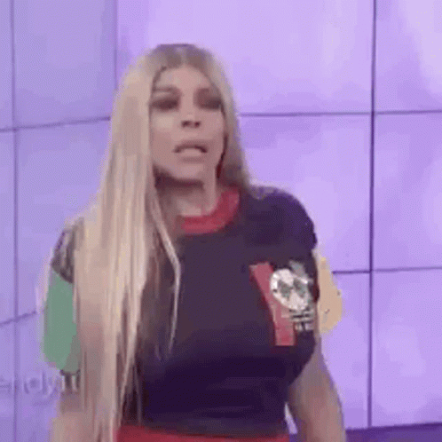 A Woman With Long Blonde Hair Is Wearing A T-Shirt With A Skull On It . GIF