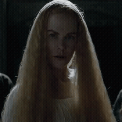 A Woman With Long Blonde Hair Is Wearing A White Dress And A Veil . GIF