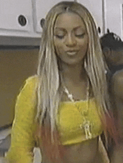 a woman with long blonde hair is wearing a yellow crop top