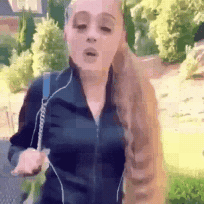 A Woman With Long Blonde Hair Is Wearing Headphones And A Black Jacket GIF
