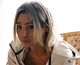 A Woman With Long Blonde Hair Wearing A White Jacket GIF