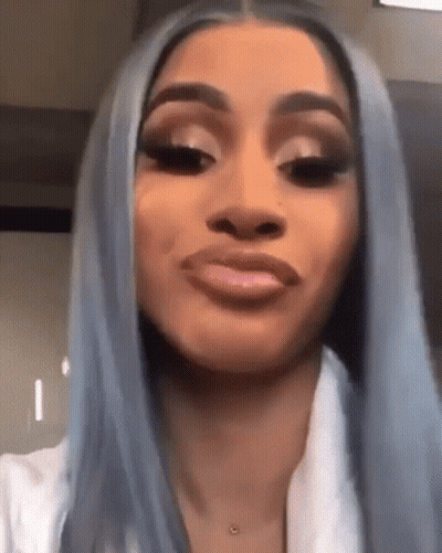 A Woman With Long Blue Hair Is Making A Funny Face . GIF
