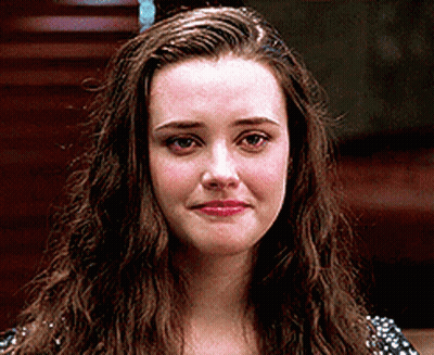 A Woman With Long Brown Hair Is Looking At The Camera With A Sad Look On Her Face . GIF