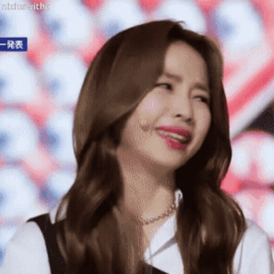 A Woman With Long Brown Hair Is Making A Funny Face With Her Mouth Open . GIF