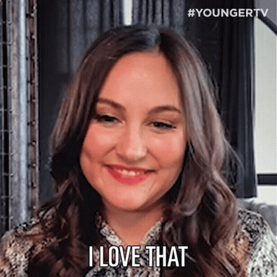 A Woman With Long Brown Hair Is Smiling And Saying `` I Love That '' . GIF