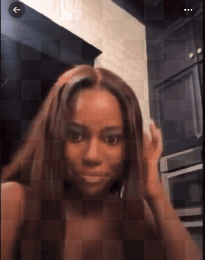 A Woman With Long Brown Hair Is Standing In A Kitchen With An Arrow Pointing To The Right GIF