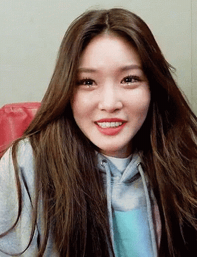 A Woman With Long Brown Hair Wearing A Grey Hoodie GIF