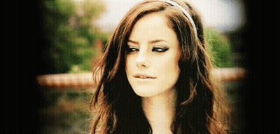 A Woman With Long Brown Hair Wearing A Headband Looks At The Camera GIF