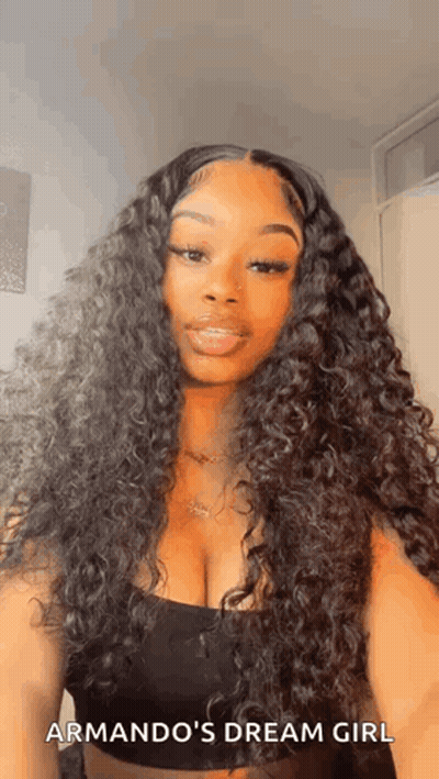 A Woman With Long Curly Hair And A Plunging Neckline Is Wearing A Black Tank Top . GIF