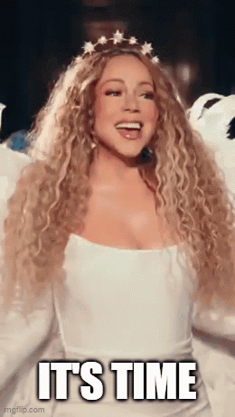 A Woman With Long Curly Hair Is Wearing A White Dress And A Crown . GIF