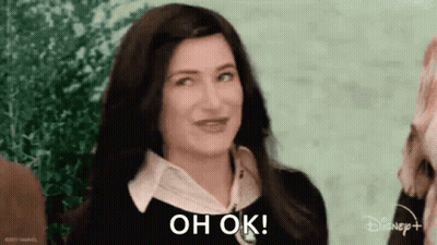 A Woman With Long Dark Hair Is Smiling And Says `` Oh Ok '' . GIF