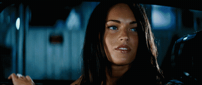 A Woman With Long Dark Hair Is Smiling While Sitting In A Car GIF