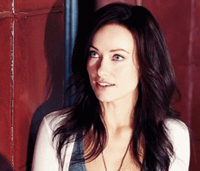 A Woman With Long Dark Hair Is Wearing A White Cardigan GIF