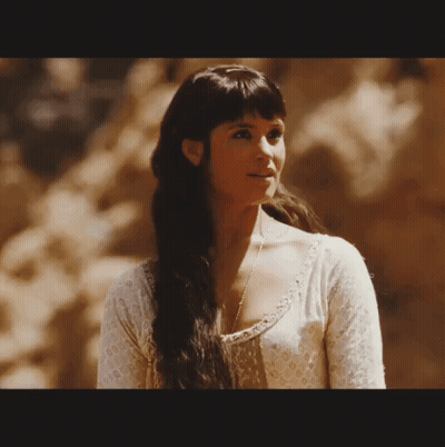 A Woman With Long Dark Hair Wearing A White Shirt GIF