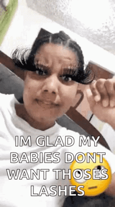 A Woman With Long Eyelashes Is Making A Funny Face And Holding A Smiley Face . GIF