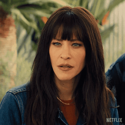 A Woman With Long Hair And Bangs Is Wearing A Denim Jacket From Netflix GIF