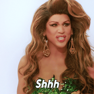 A Woman With Long Hair And Earrings Says Shhh On Her Face GIF