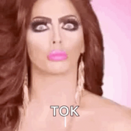 A Woman With Long Hair And Pink Lips Is Making A Funny Face And Says Tok . GIF