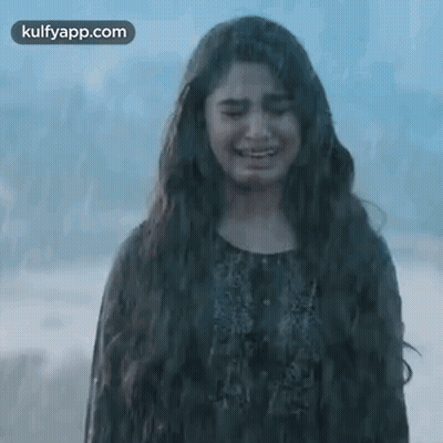 A Woman With Long Hair Is Crying While Standing On The Beach . GIF
