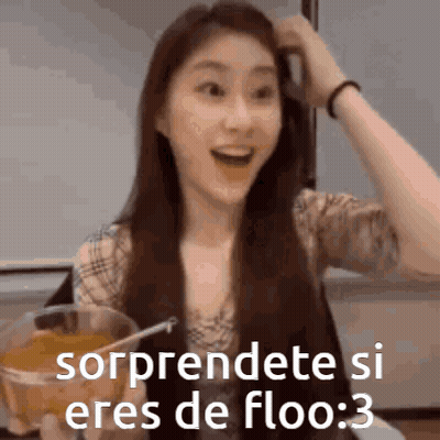 A Woman With Long Hair Is Holding A Glass Of Orange Juice And Making A Funny Face . GIF