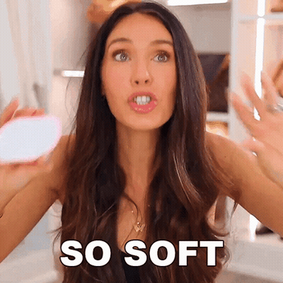 A Woman With Long Hair Is Holding A Mirror And Saying " So Soft " GIF