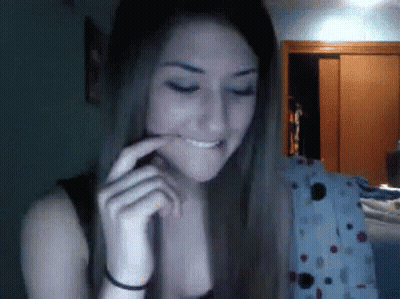 A Woman With Long Hair Is Making A Funny Face And Smiling GIF