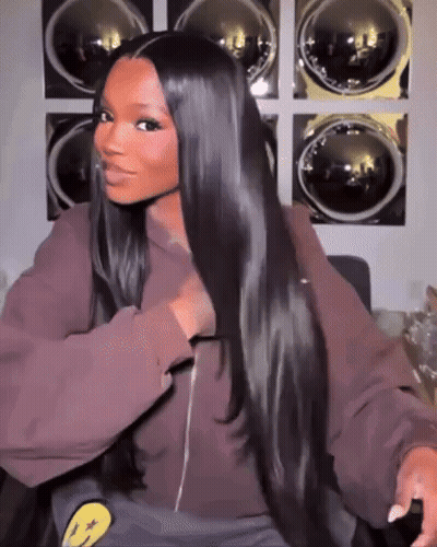 a woman with long hair is sitting in front of a laundromat .