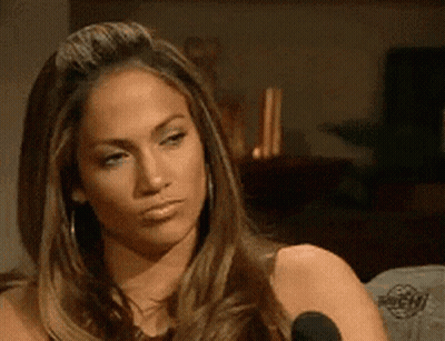 A Woman With Long Hair Is Sitting In Front Of A Microphone And Making A Face . GIF