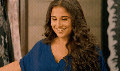 A Woman With Long Hair Is Smiling And Wearing A Blue Dress GIF