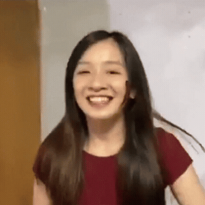 A Woman With Long Hair Is Smiling For The Camera . GIF