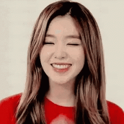 A Woman With Long Hair Is Smiling With Her Eyes Closed . GIF