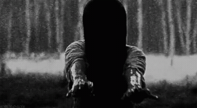 A Woman With Long Hair Is Standing In Front Of A Waterfall . GIF