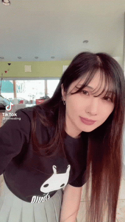 A Woman With Long Hair Is Wearing A Black T-Shirt With A White Rabbit On It . GIF
