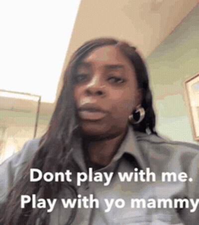 A Woman With Long Hair Is Wearing A Grey Shirt And Earrings And Says Dont Play With Me Play With Yo Mammy . GIF